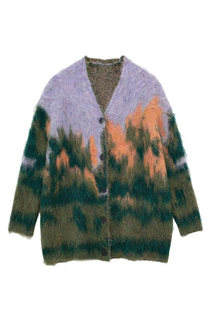 Multi - Woman wearing an oversized, fluffy knit cardigan featuring an abstract landscape pattern in shades of green, purple, and orange over a black turtleneck.