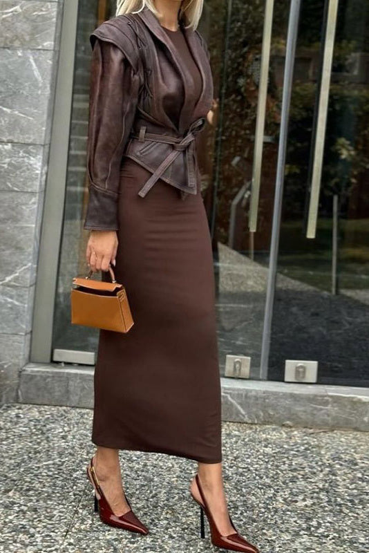 Wine Red - A woman wearing a dark brown, structured wrap faux leather jacket with a tie waist, pronounced shoulders with lace-up details, and a pointed peplum hem.