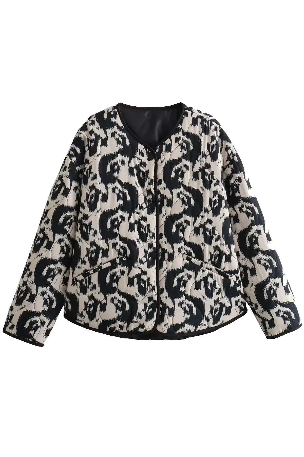 Black - Woman wearing a smart casual quilted collarless jacket with an abstract black and white print, layered over a white top and black bottoms.