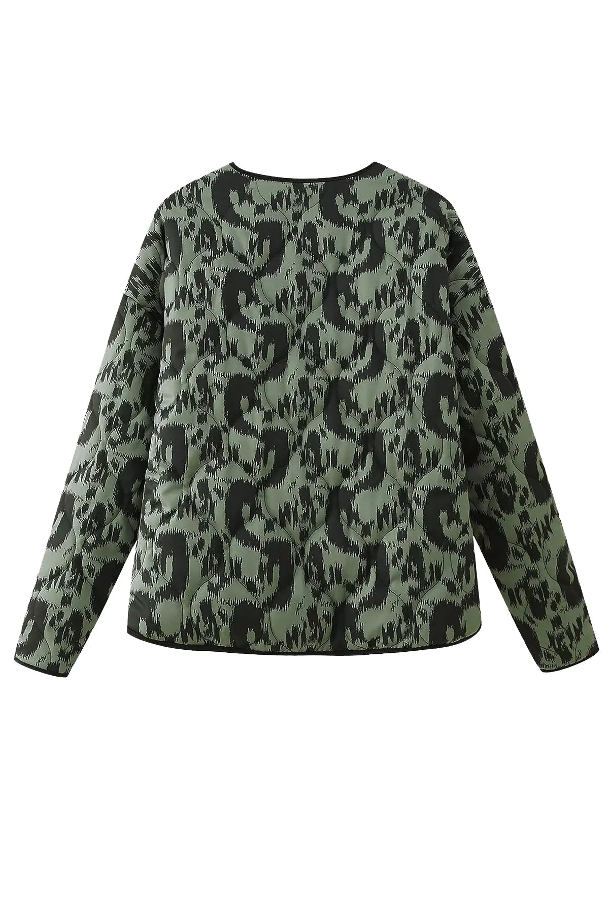 Green - Woman wearing a smart casual quilted collarless jacket with an abstract black and white print, layered over a white top and black bottoms.