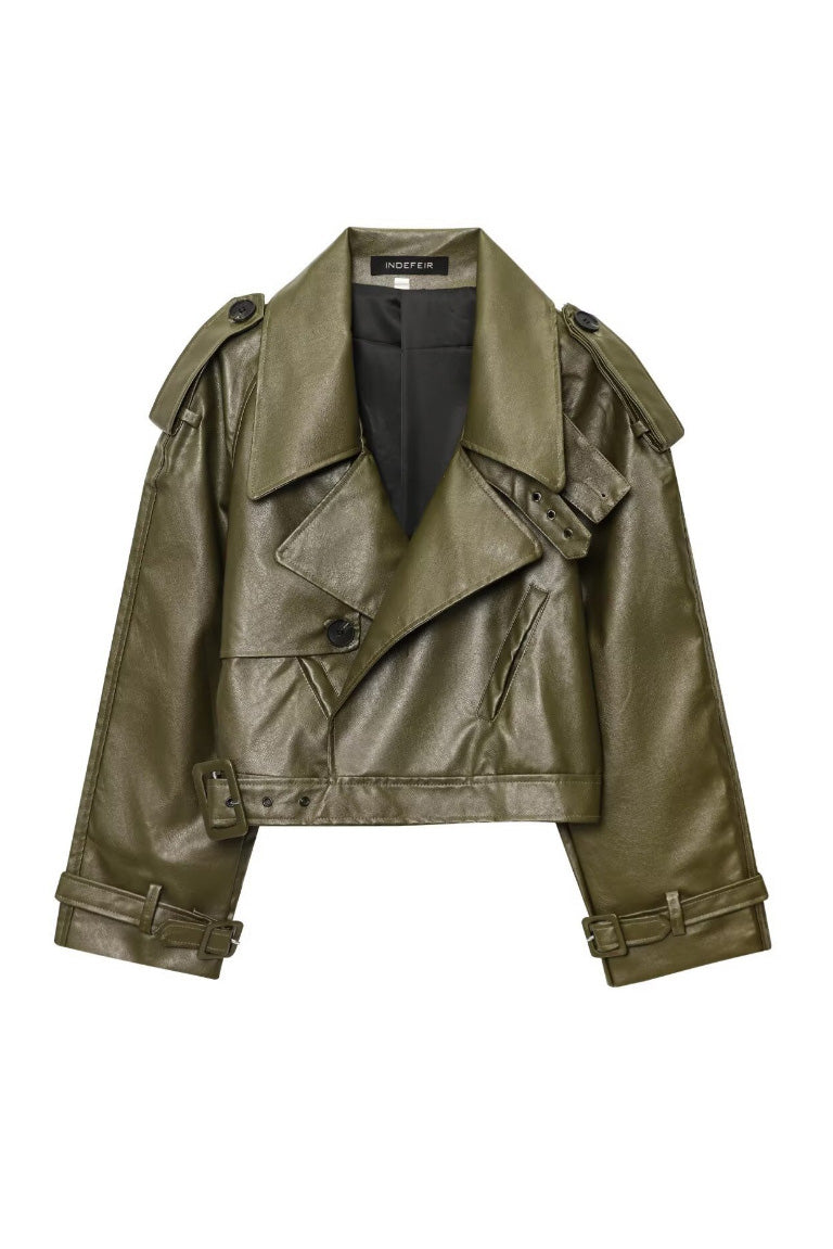 Green - Woman wearing an oversized burgundy faux leather moto jacket with exaggerated shoulders, wide collar, and belted cuffs, styled in a chic city setting.