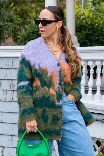Multi - Woman wearing an oversized, fluffy knit cardigan featuring an abstract landscape pattern in shades of green, purple, and orange over a black turtleneck.