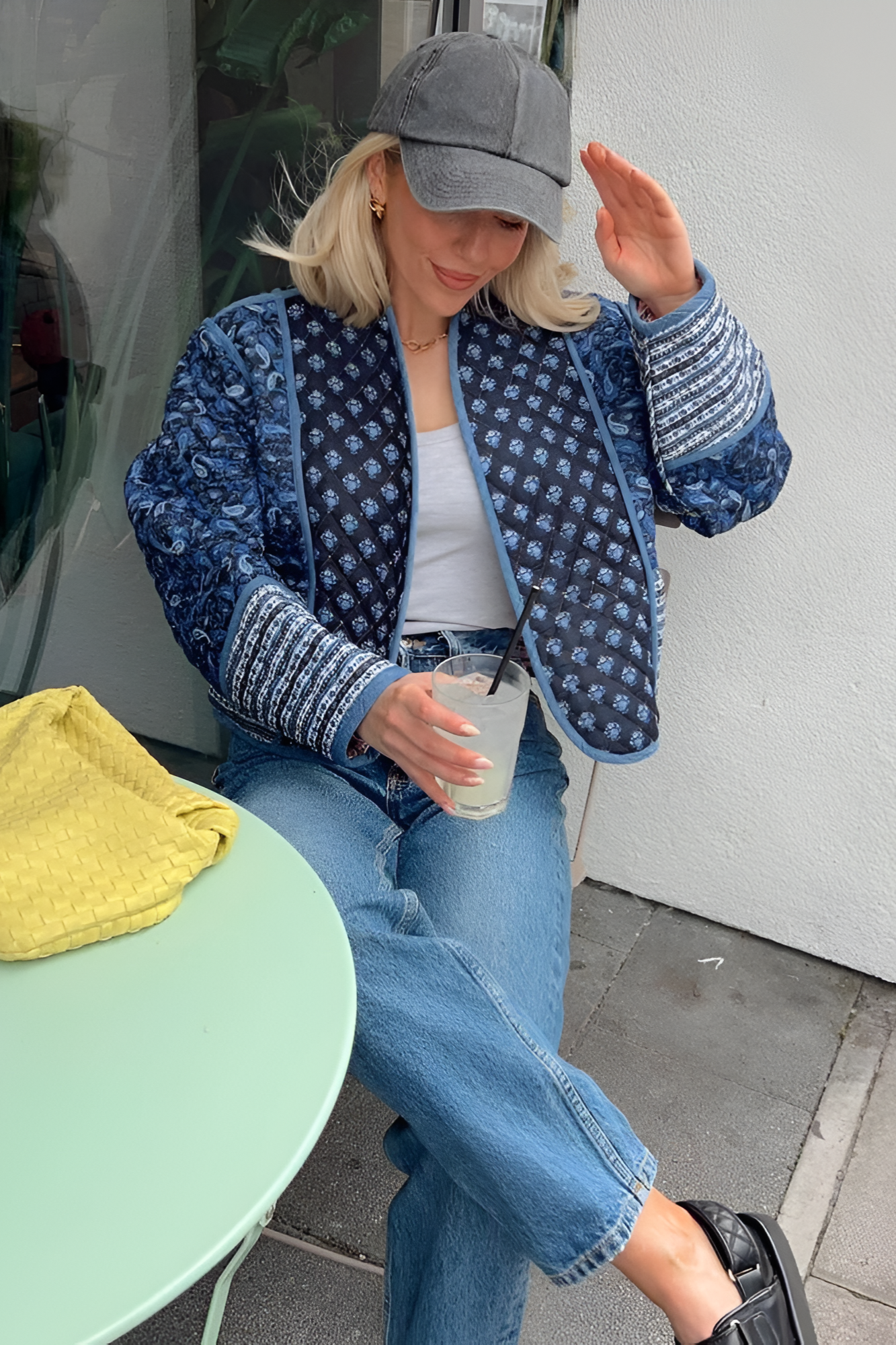 Pink - Women's open-front quilted jacket featuring a pink and white floral block print, contrasting blue edge binding, and diamond stitching, worn over a white tee and light wash jeans.
