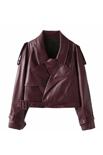 Red - Woman wearing an oversized burgundy faux leather moto jacket with exaggerated shoulders, wide collar, and belted cuffs, styled in a chic city setting.