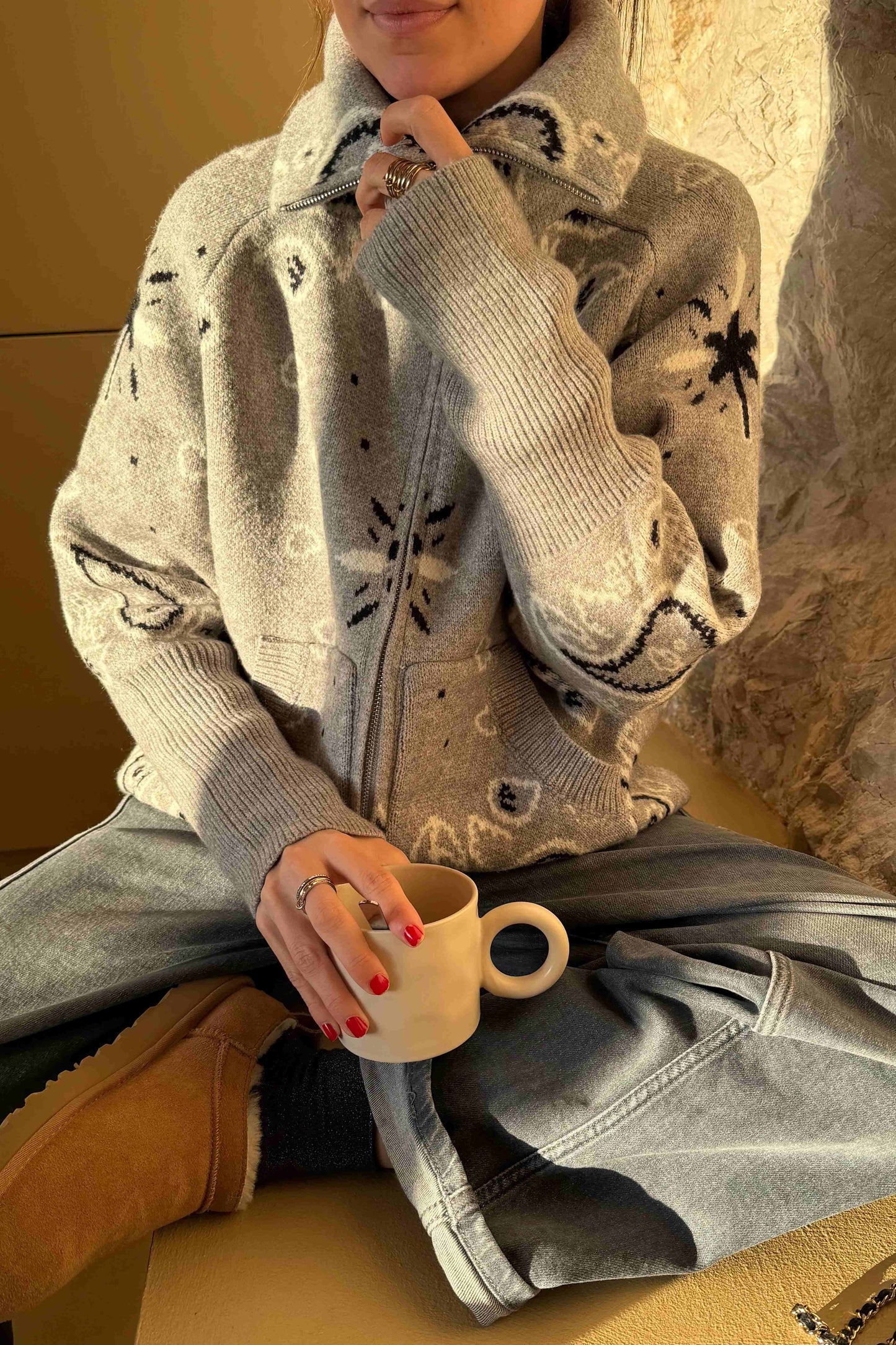 Grey - Woman taking a mirror selfie wearing a grey zip-up knit sweater with a black and white bandana pattern, featuring a high funnel neck and front pockets.