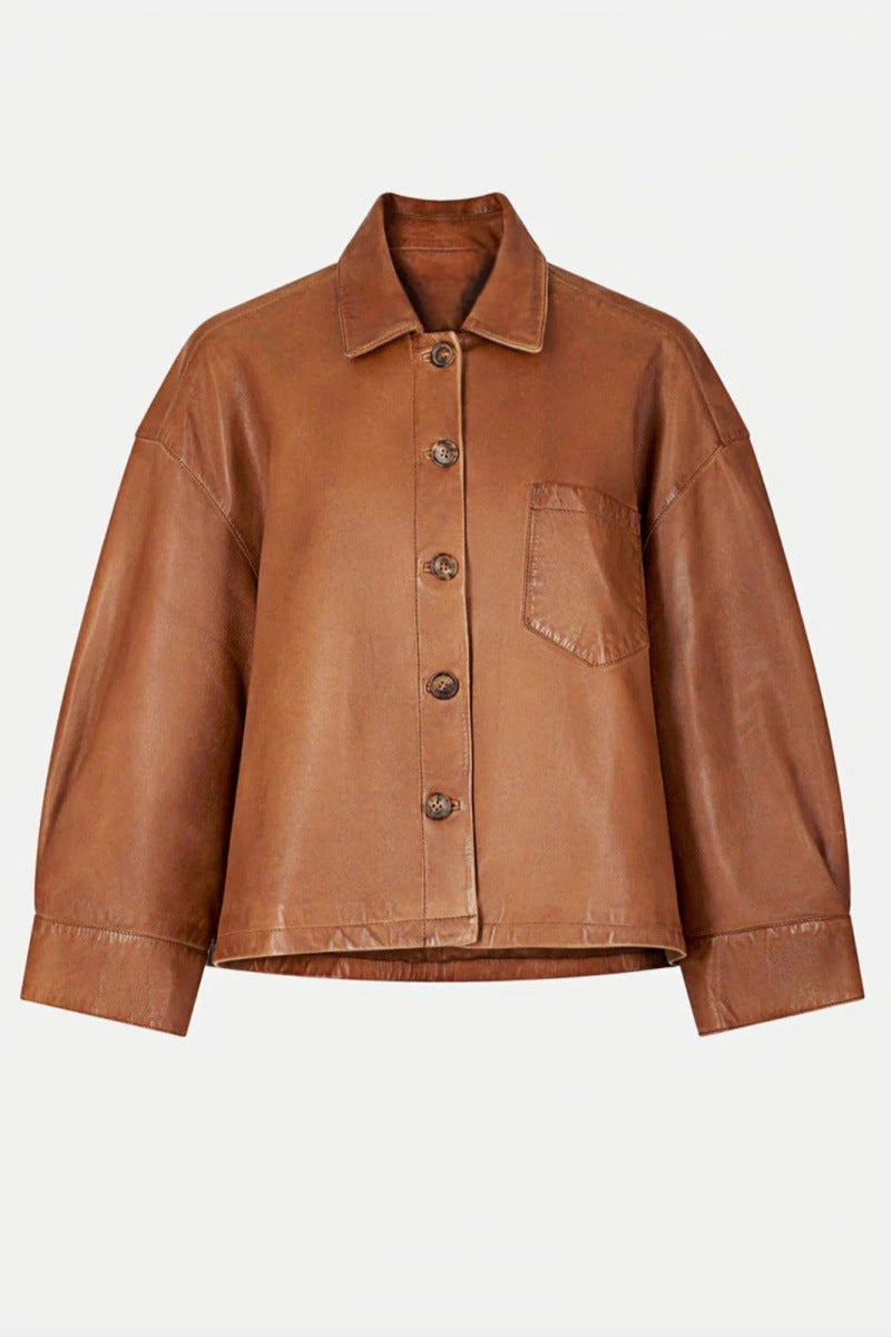 Brown - A woman wearing a relaxed-fit, brown faux leather button-front jacket with a classic collar and single chest pocket, styled over a patterned knit sweater.