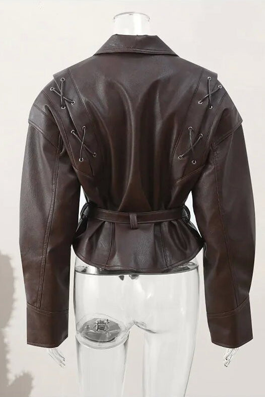 Wine Red - A woman wearing a dark brown, structured wrap faux leather jacket with a tie waist, pronounced shoulders with lace-up details, and a pointed peplum hem.