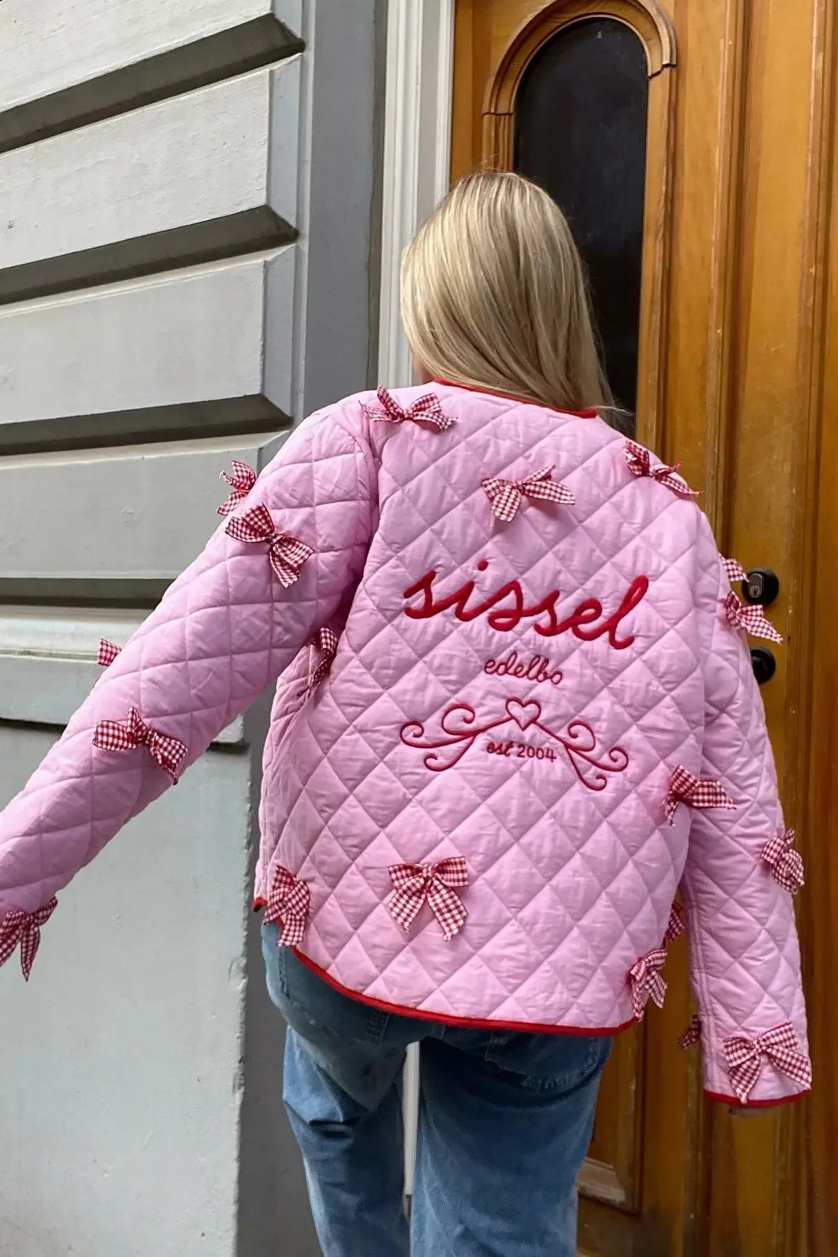 Pink - Women's pink diamond-quilted jacket featuring red contrast trim, red tie-front closures, and decorative red and white gingham bows.