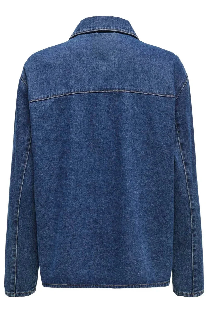 Blue - A woman taking a mirror selfie wearing a blue denim jacket featuring three tie-front closures and patch pockets, paired with wide-leg denim trousers.