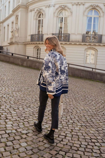 Women's oversized quilted jacket featuring a navy and white toile scenic print, open front, and contrast striped borders on the wide sleeves and hem.