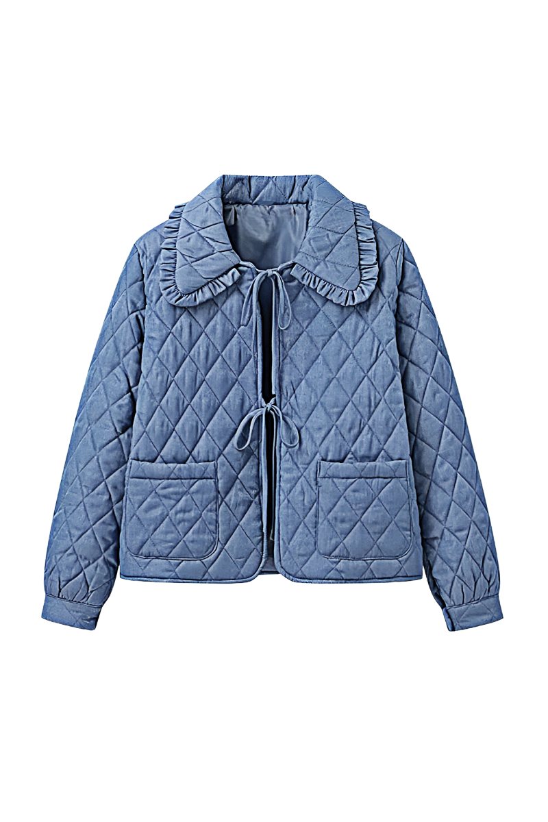 Women's blue diamond-quilted denim jacket featuring a ruffled collar, tie-front closure, and voluminous balloon sleeves, styled with distressed shorts and cowboy boots.