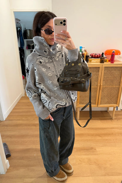 Grey - Woman taking a mirror selfie wearing a grey zip-up knit sweater with a black and white bandana pattern, featuring a high funnel neck and front pockets.