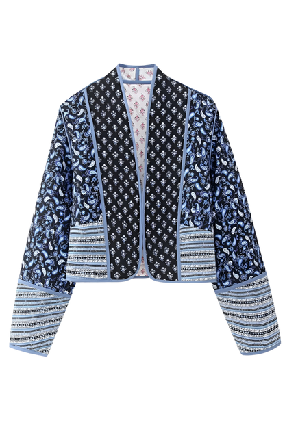 Blue - Women's open-front quilted jacket featuring a pink and white floral block print, contrasting blue edge binding, and diamond stitching, worn over a white tee and light wash jeans.