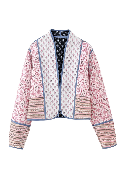 Pink - Women's open-front quilted jacket featuring a pink and white floral block print, contrasting blue edge binding, and diamond stitching, worn over a white tee and light wash jeans.