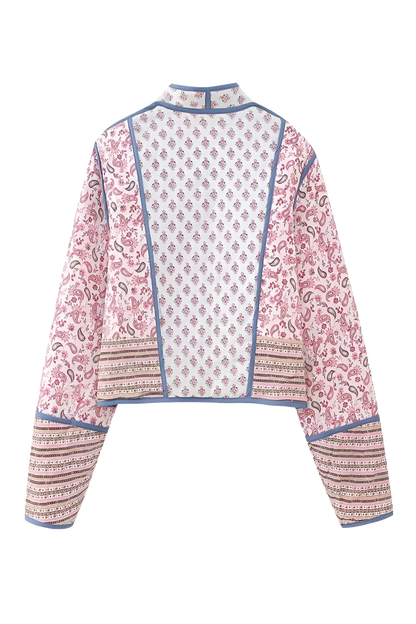 Pink - Women's open-front quilted jacket featuring a pink and white floral block print, contrasting blue edge binding, and diamond stitching, worn over a white tee and light wash jeans.