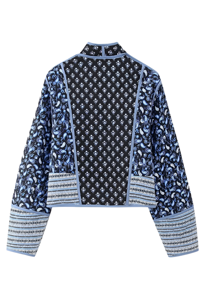 Blue - Women's open-front quilted jacket featuring a pink and white floral block print, contrasting blue edge binding, and diamond stitching, worn over a white tee and light wash jeans.