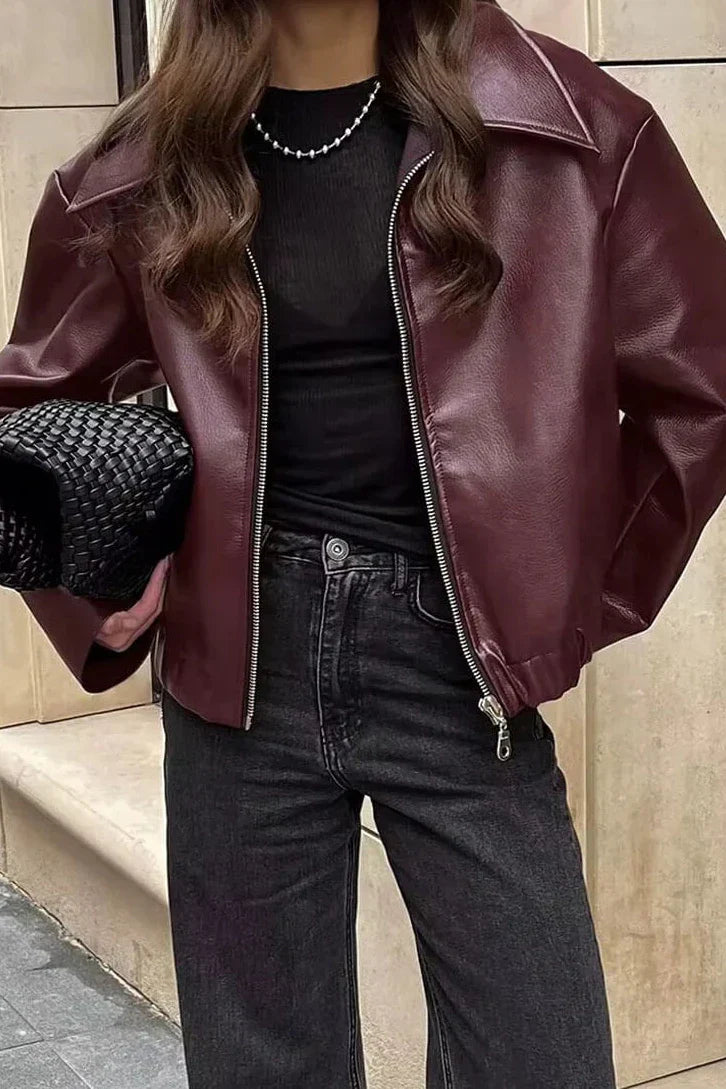 Amaranth - Women's deep burgundy faux leather zip-front cropped bomber jacket with a wide collar, styled over a black top and dark denim.