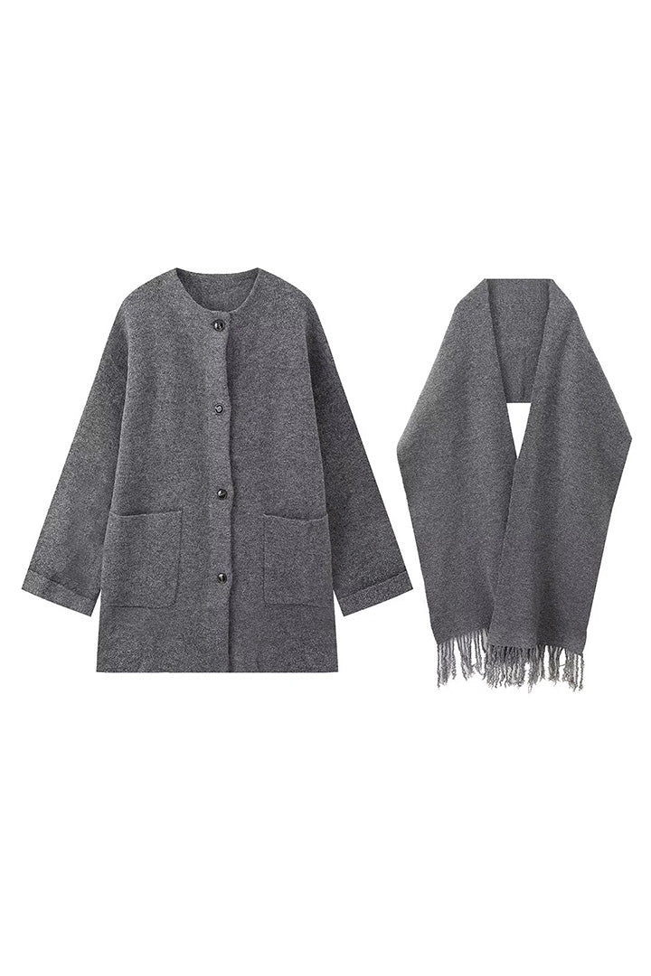 Grey - A woman wearing a taupe brushed wool mid-length coat with an integrated matching scarf, styled with dark sunglasses and a plum clutch against a classic brick building background.
