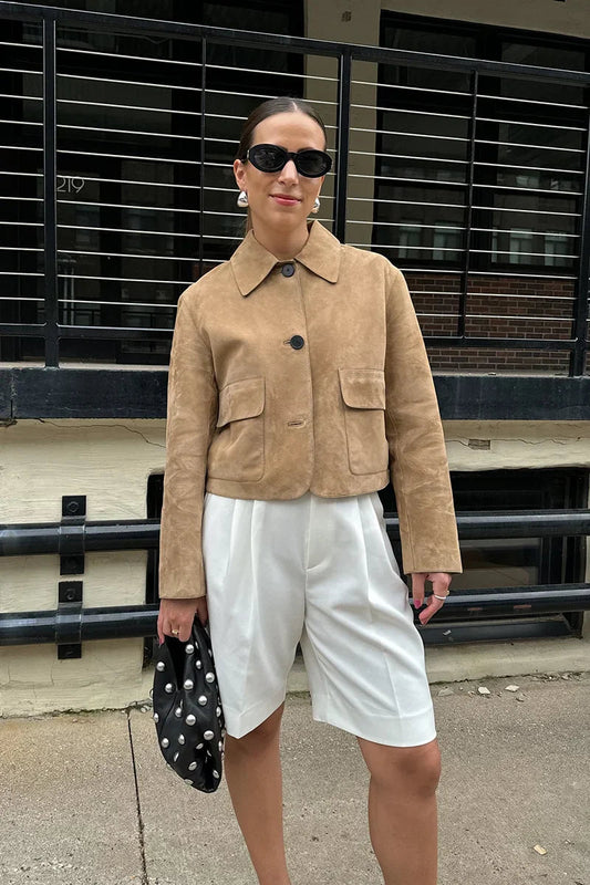 sand - Women's tan suede-look cropped jacket featuring a point collar, large button closures, and two front flap pockets, styled over white tailored shorts.