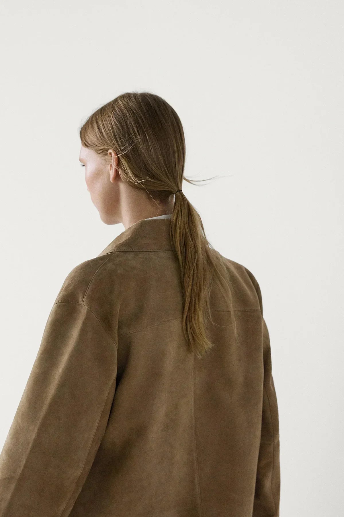 sand - Women's tan suede-look cropped jacket featuring a point collar, large button closures, and two front flap pockets, styled over white tailored shorts.