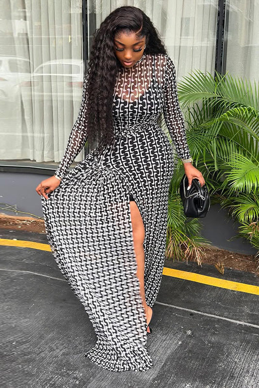 Black - A woman wearing a long-sleeved maxi dress featuring a black and white geometric chain link print, sheer mesh neckline, ruched waist detailing, and a high thigh slit.