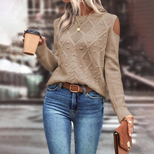 Khaki - Women's beige long-sleeve knit sweater featuring cold shoulder cutouts, a crew neckline, and a textured cable knit pattern with bobble details, styled casually with blue jeans.