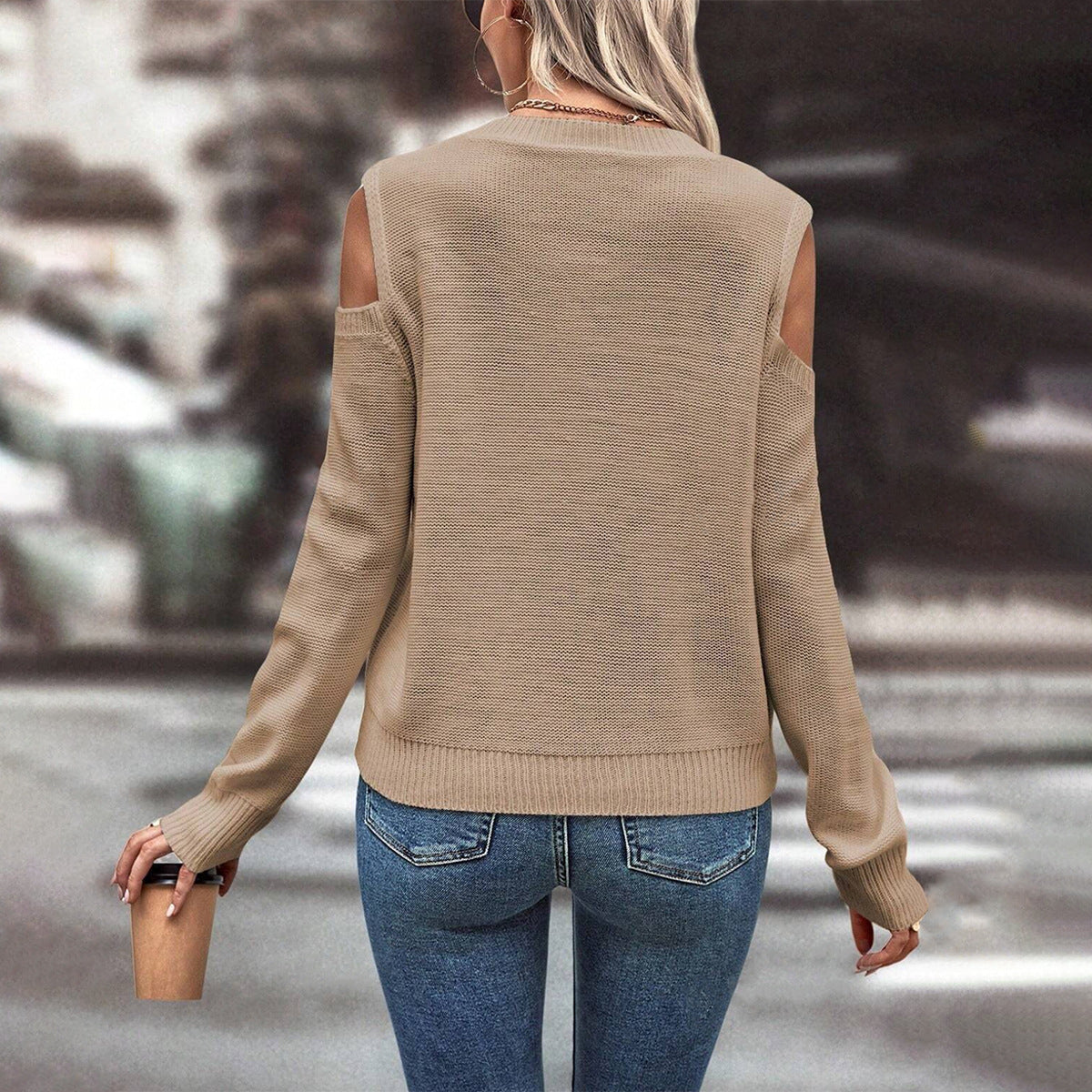 Khaki - Women's beige long-sleeve knit sweater featuring cold shoulder cutouts, a crew neckline, and a textured cable knit pattern with bobble details, styled casually with blue jeans.