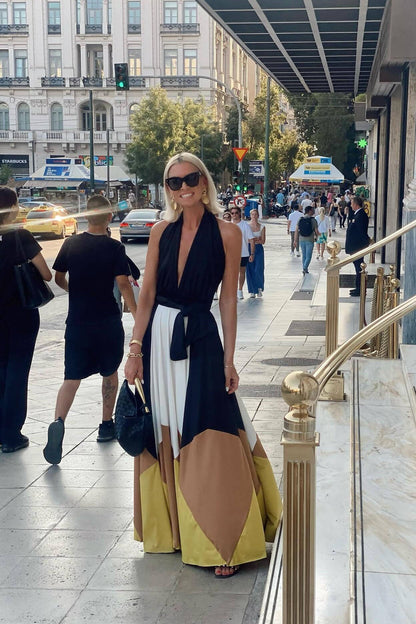 Multi - Women's flowing halter maxi dress featuring a deep V-neckline, tie waist, and a voluminous skirt with bold geometric colour block panels.