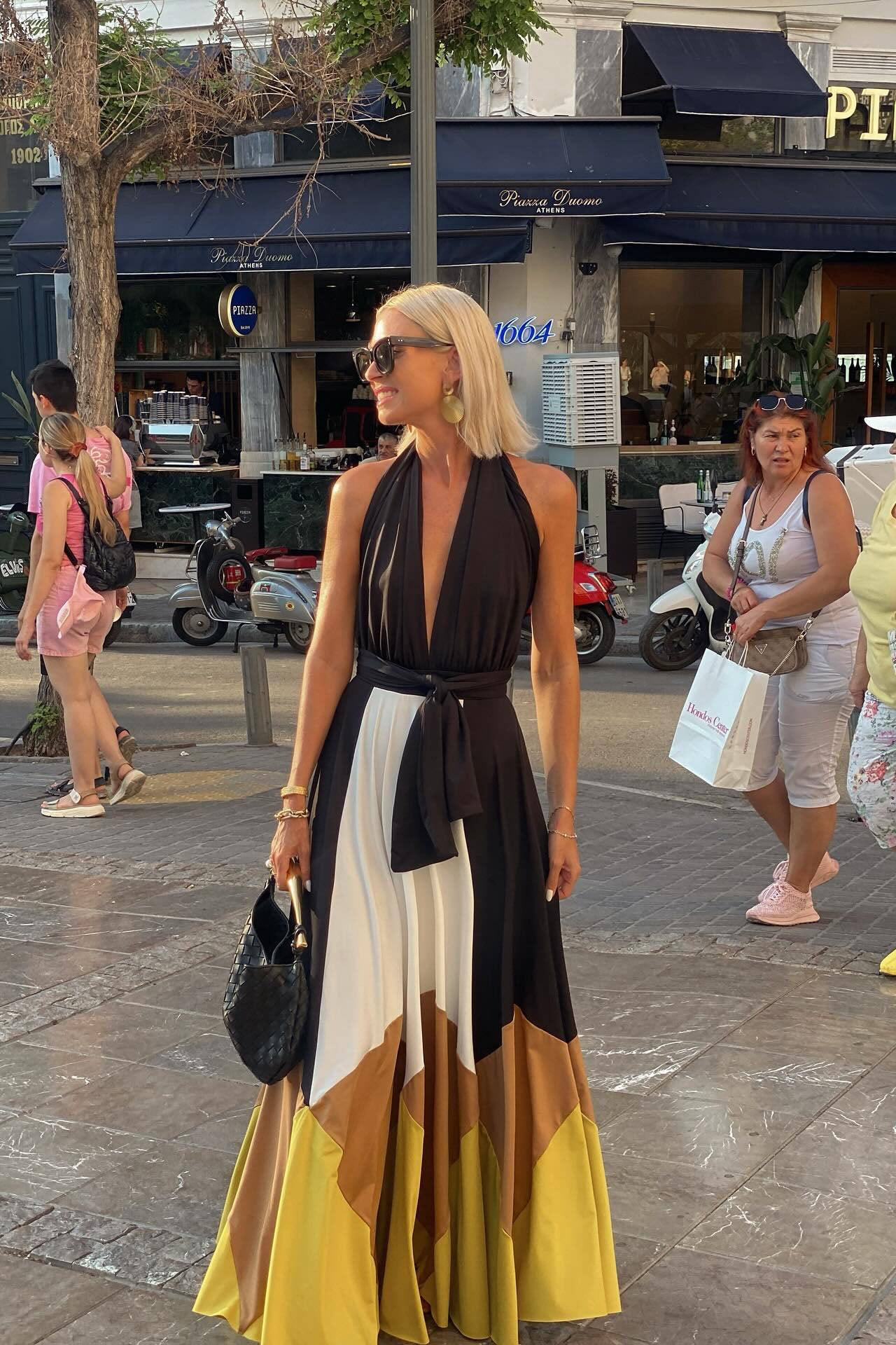 Multi - Women's flowing halter maxi dress featuring a deep V-neckline, tie waist, and a voluminous skirt with bold geometric colour block panels.