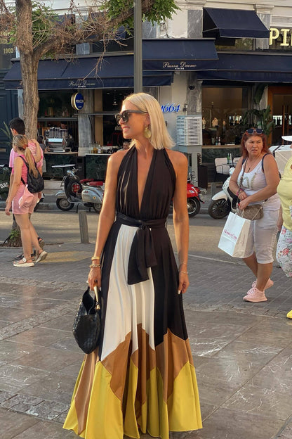 Multi - Women's flowing halter maxi dress featuring a deep V-neckline, tie waist, and a voluminous skirt with bold geometric colour block panels.