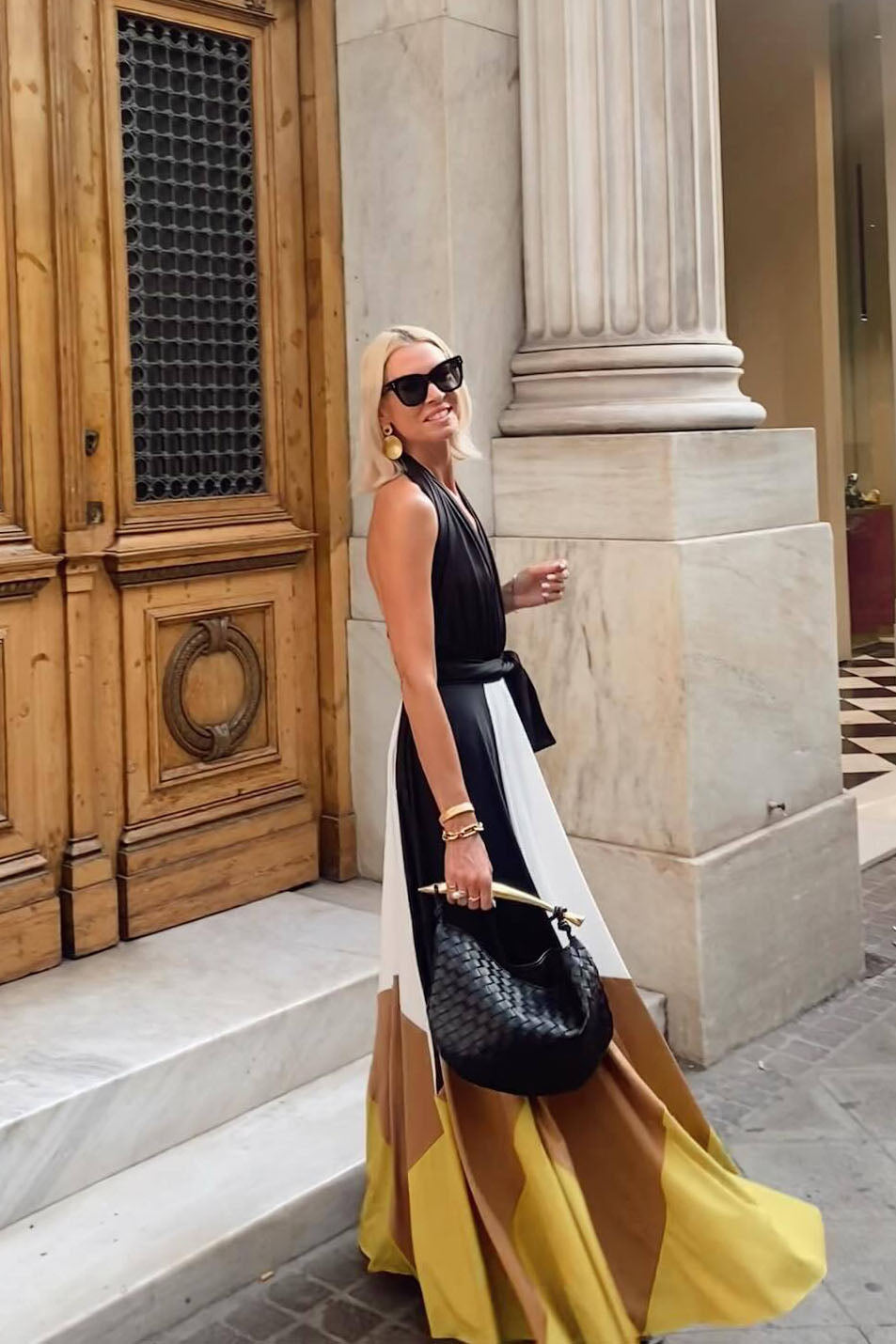 Multi - Women's flowing halter maxi dress featuring a deep V-neckline, tie waist, and a voluminous skirt with bold geometric colour block panels.