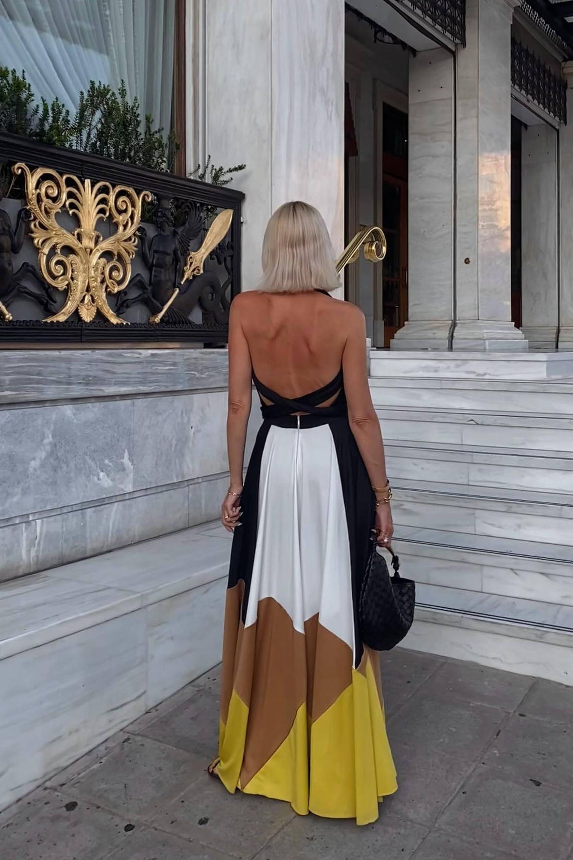 Multi - Women's flowing halter maxi dress featuring a deep V-neckline, tie waist, and a voluminous skirt with bold geometric colour block panels.