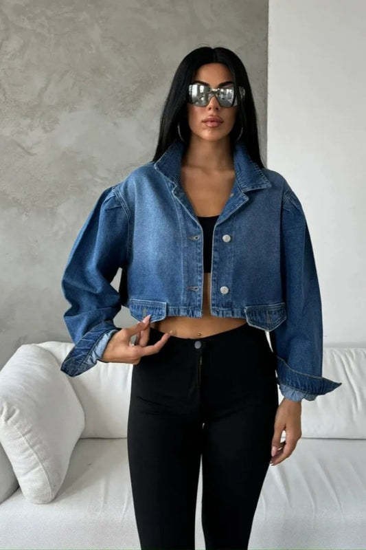 Blue - Women's cropped denim jacket featuring voluminous puff sleeves, a classic collar, and a faded wash, styled open over a black top and high-waisted pants.