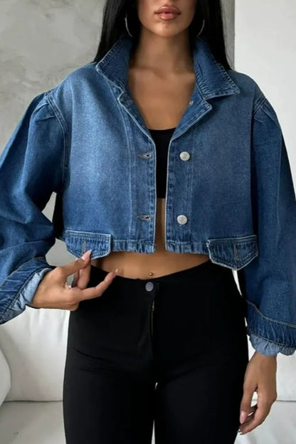 Blue - Women's cropped denim jacket featuring voluminous puff sleeves, a classic collar, and a faded wash, styled open over a black top and high-waisted pants.