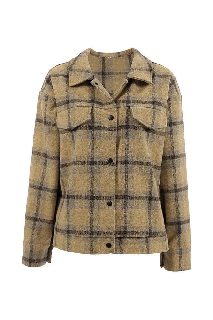Plaid - Woman wearing an oversized yellow and brown plaid shirt jacket over a white fluffy sweater and white jeans, walking down a city street.