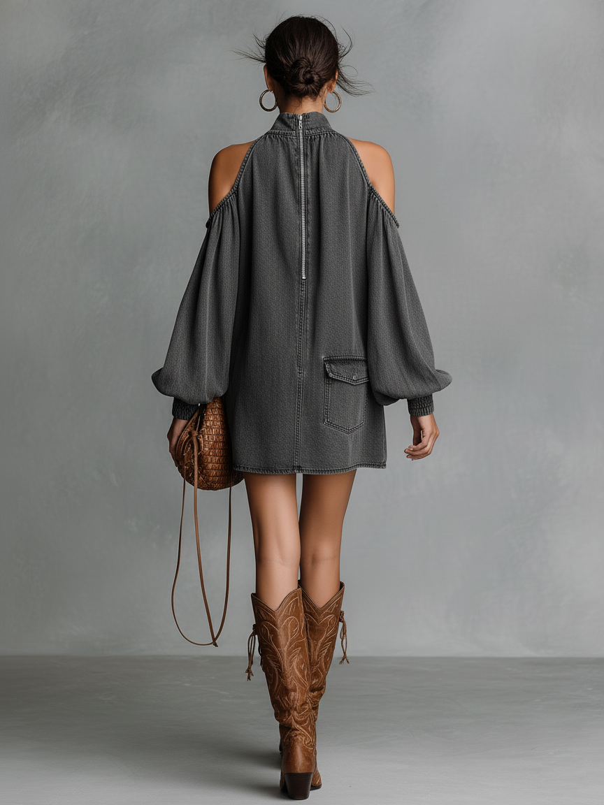 Dark Gray - A person wearing a washed charcoal grey denim mini dress featuring a high neck, cold-shoulder cutouts, long balloon sleeves, and a single chest pocket, paired with brown embroidered cowboy boots.