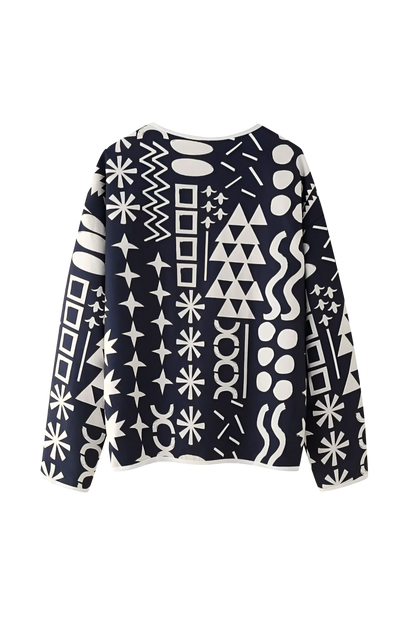 Dark Blue - Woman wearing a navy blue quilted open-front jacket with bold white abstract geometric embroidery, styled with jeans and sandals.