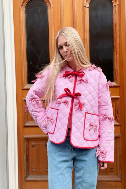 Pink - Women's pink diamond-quilted jacket featuring red contrast trim, red tie-front closures, and decorative red and white gingham bows.