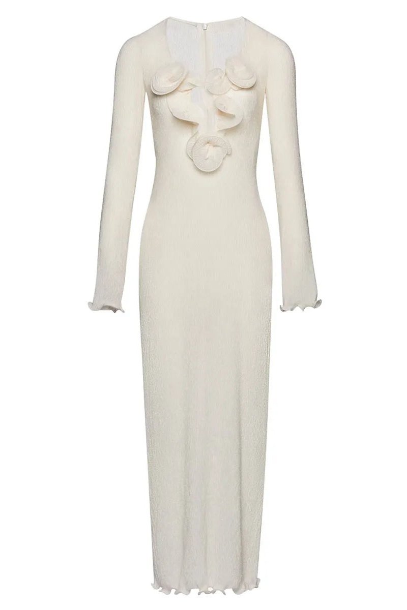 White - A woman wearing a long-sleeved, white ribbed knit maxi dress featuring a deep plunging neckline decorated with large 3D floral appliqués.