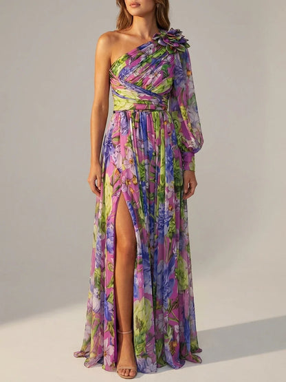 Purple - A woman wearing a vibrant floral print chiffon one-shoulder maxi dress with a single long balloon sleeve, ruched bodice, and a high leg slit.