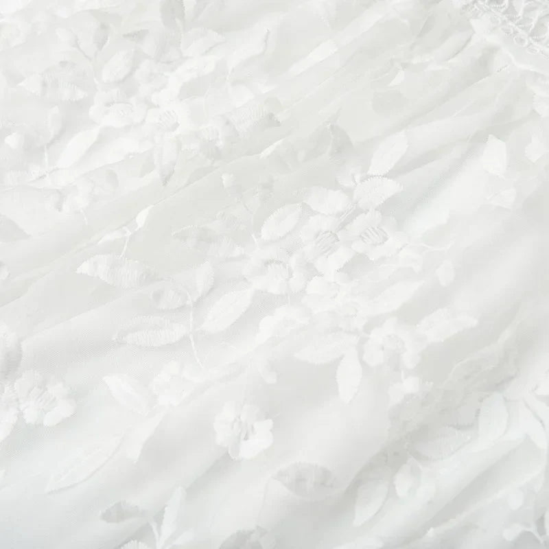 White - White floral appliqué tulle mini dress featuring a deep plunge neckline, crochet-trimmed waist, and a fluid A-line skirt.