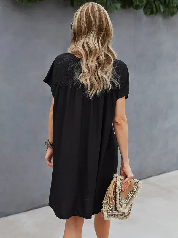 Black - Black short-sleeve mini dress featuring vibrant geometric and floral folkloric patterns with a gathered yoke and relaxed shift silhouette.