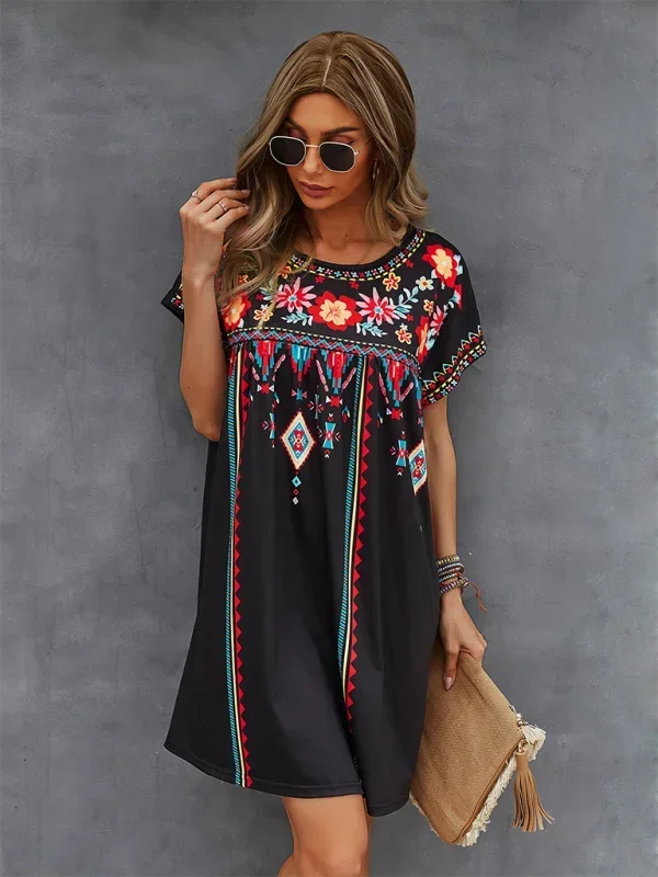 Black - Black short-sleeve mini dress featuring vibrant geometric and floral folkloric patterns with a gathered yoke and relaxed shift silhouette.