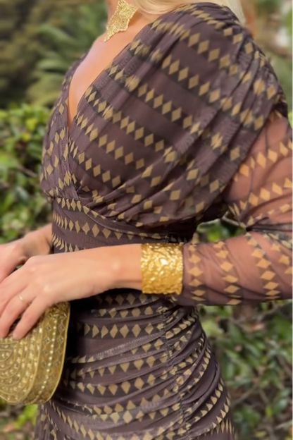 Brown - Women's resort-style maxi dress featuring a V-neckline, ruched waist, sheer three-quarter sleeves, and a flowing skirt with a geometric diamond pattern.