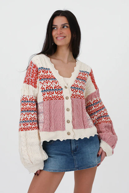 Multi-color - Women's chunky V-neck cardigan featuring a patchwork design of pink, red, and cream Fair Isle patterns and cable knit textures, finished with scalloped edges and metallic buttons.