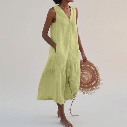 Green - A woman wearing a sleeveless white linen midi dress with a V-neck, button-down front, and tiered skirt, holding a wide-brimmed straw hat against a neutral background.