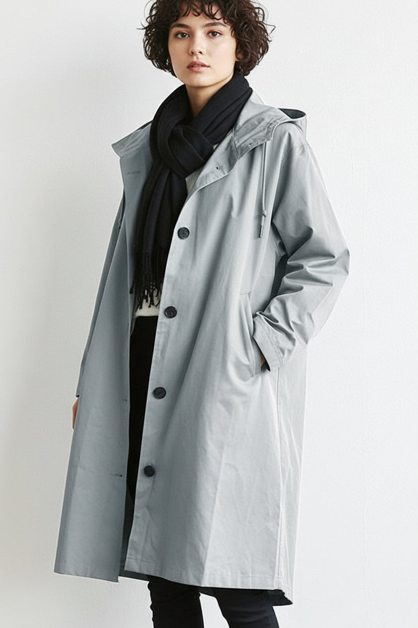 Grey - A model wearing a light grey mid-length hooded coat with a single-breasted button front, styled with a black scarf and black pants against a plain white background.