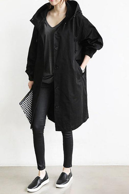 Black - A model wearing a light grey mid-length hooded coat with a single-breasted button front, styled with a black scarf and black pants against a plain white background.