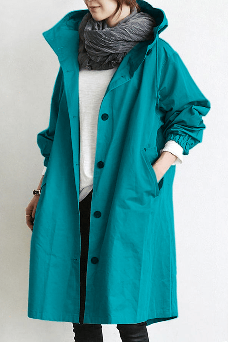 Turquoise - A model wearing a light grey mid-length hooded coat with a single-breasted button front, styled with a black scarf and black pants against a plain white background.