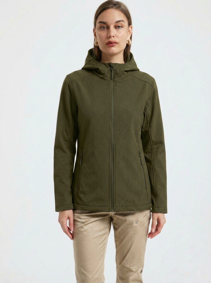 Green - A woman wearing a structured olive green matte technical hooded jacket with a front zip closure, panelled seam detailing, and zippered pockets, paired with beige trousers.